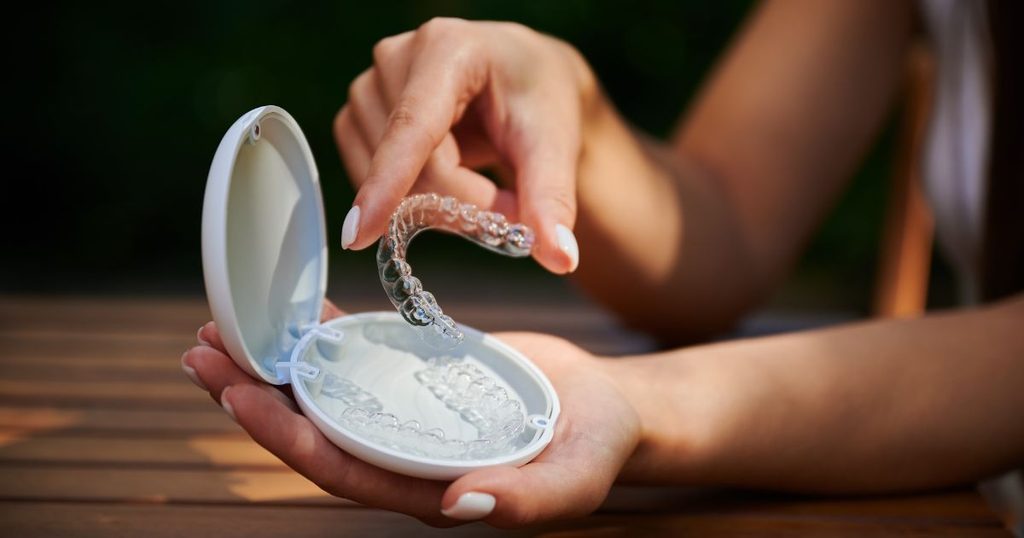 Patient removing Invisalign aligners before eating.