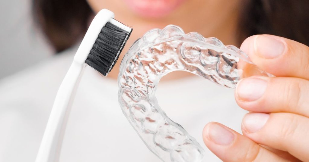 Cleaning Invisalign with a brush