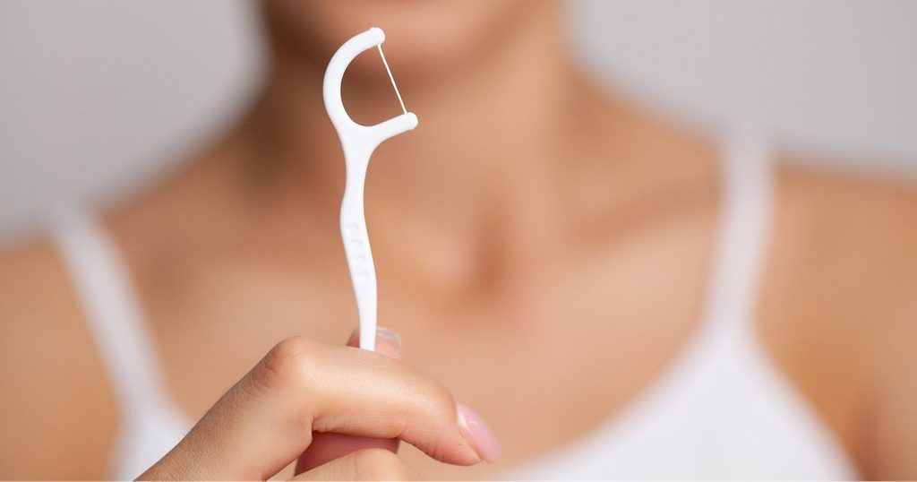 Fregar con forma de C para eliminar la placa entre los dientes