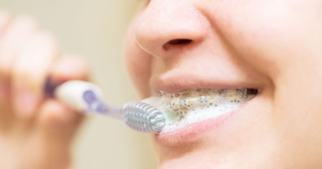 Cepillo dental con la punta hacia la línea de las encías para eliminar la placa